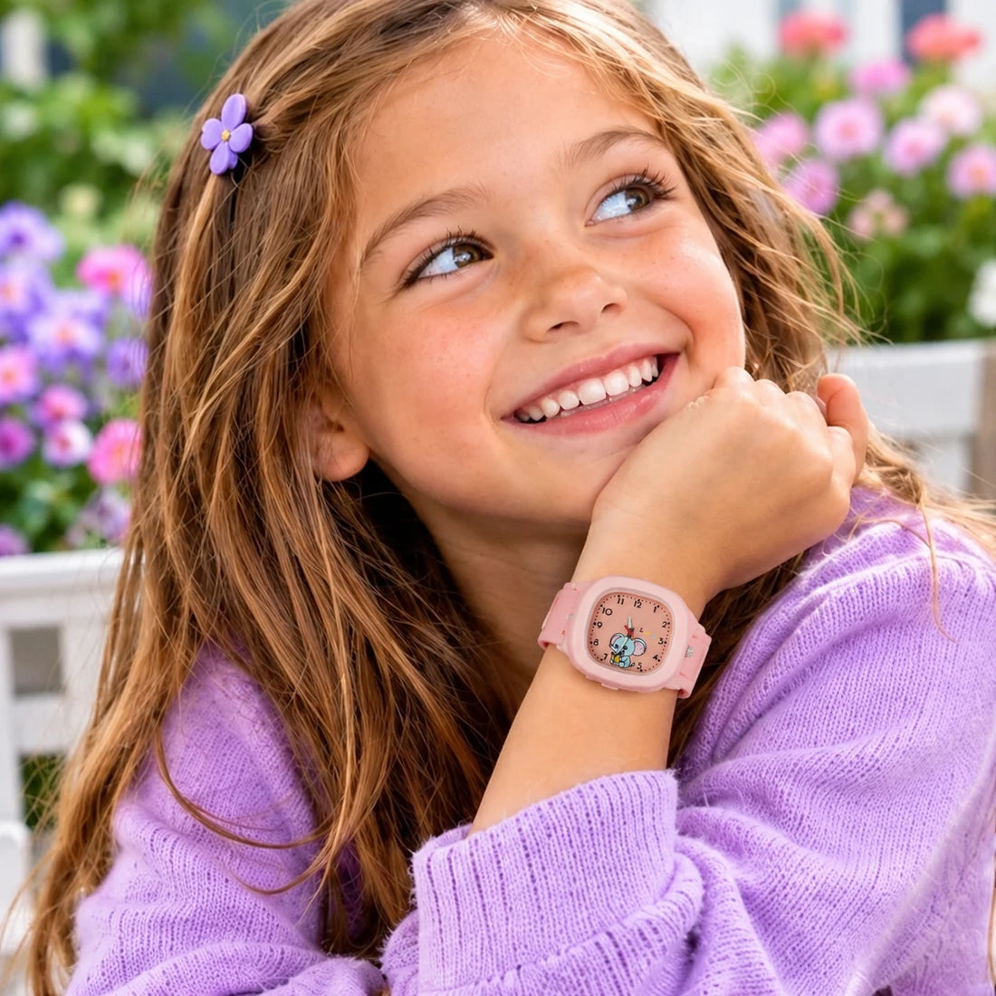 Une petite fille porte la montre Trompette rose